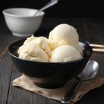scoops-vanilla-ice-cream-black-bowl-wooden-table_925819-1538